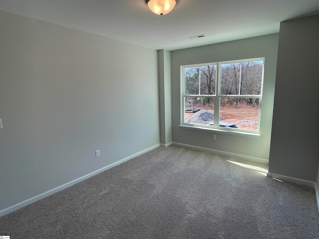 carpeted empty room featuring visible vents and baseboards