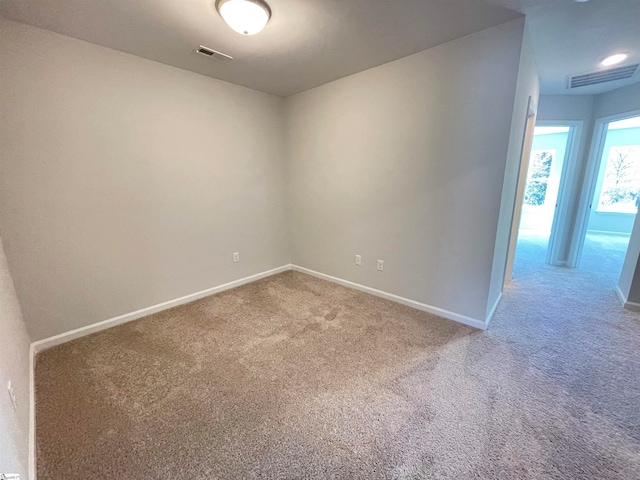 carpeted empty room featuring visible vents and baseboards