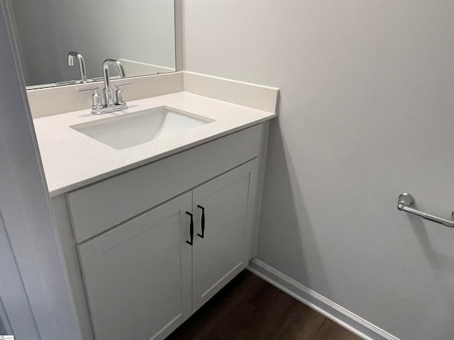 bathroom featuring vanity, wood finished floors, and baseboards