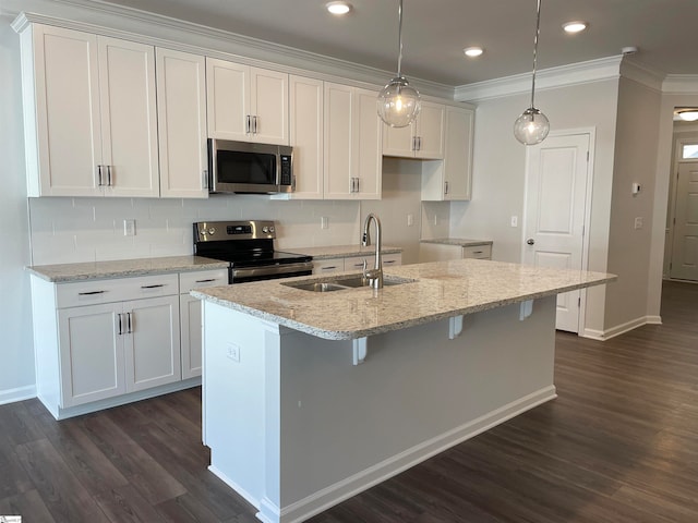 kitchen featuring appliances with stainless steel finishes, sink, an island with sink, and dark hardwood / wood-style flooring