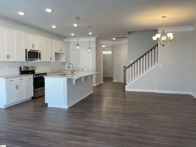 kitchen with a chandelier, an island with sink, stainless steel appliances, white cabinets, and dark hardwood / wood-style flooring