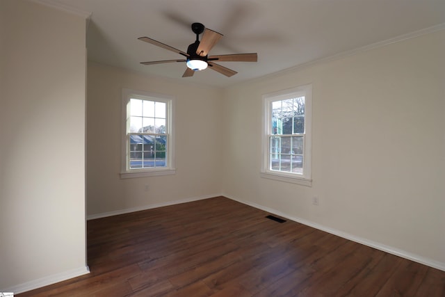 empty room with dark hardwood / wood-style flooring, plenty of natural light, ornamental molding, and ceiling fan