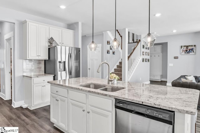 kitchen featuring white cabinetry, sink, pendant lighting, and stainless steel appliances