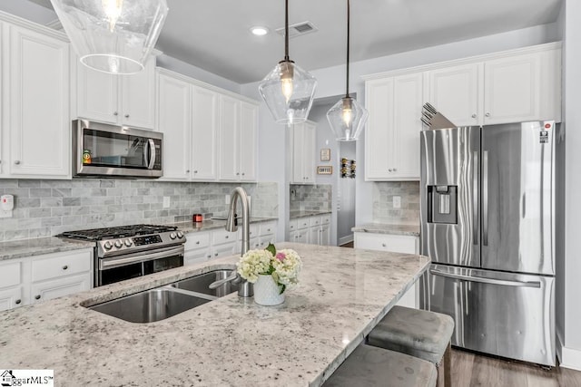 kitchen with light stone countertops, white cabinets, and appliances with stainless steel finishes