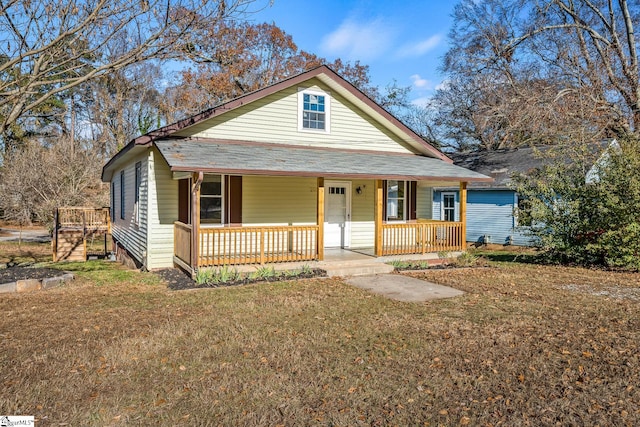 bungalow-style home with covered porch and a front lawn