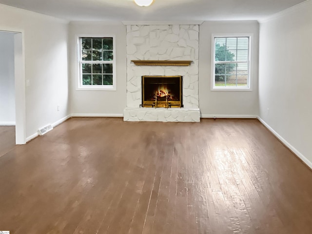 unfurnished living room with hardwood / wood-style floors and a stone fireplace