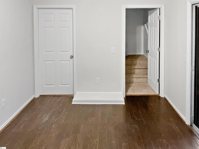 empty room with dark hardwood / wood-style flooring