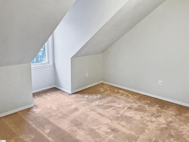 additional living space with carpet flooring and vaulted ceiling