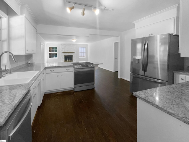 kitchen with dark wood-type flooring, kitchen peninsula, stainless steel appliances, white cabinetry, and sink