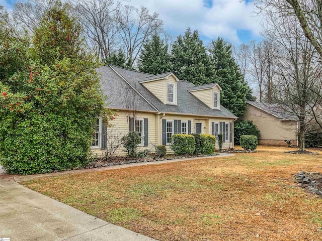 cape cod house with a front lawn