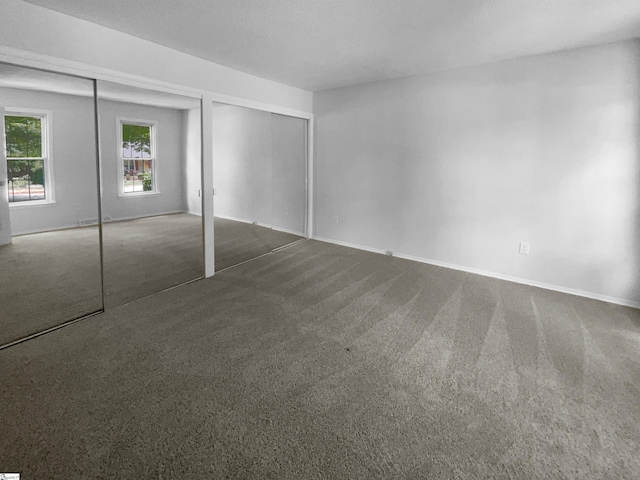 unfurnished bedroom with dark colored carpet