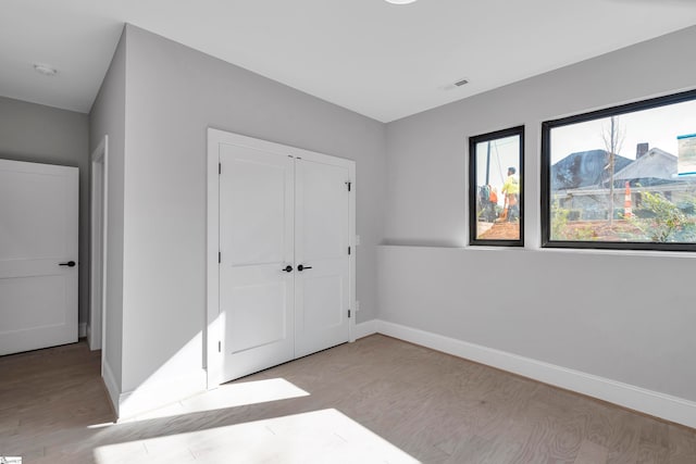 unfurnished bedroom featuring light hardwood / wood-style floors and a closet