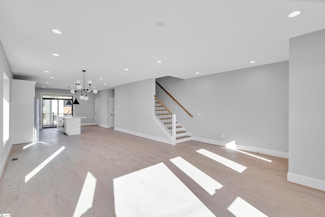 unfurnished living room with light hardwood / wood-style floors and an inviting chandelier