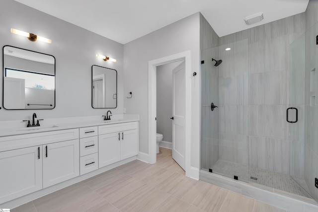 bathroom with a shower with door, vanity, and toilet