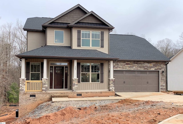 craftsman house featuring covered porch, stone siding, a shingled roof, and a garage