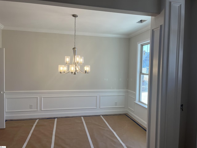 unfurnished dining area featuring a chandelier, ornamental molding, and plenty of natural light