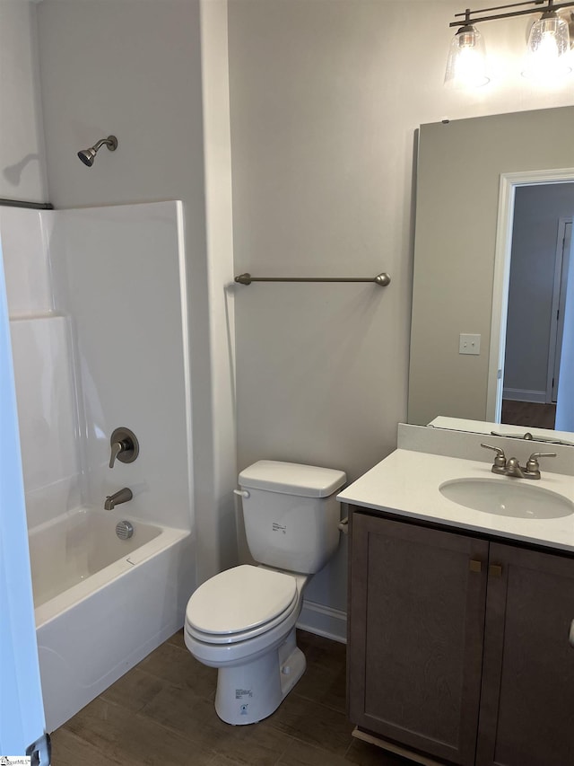 full bathroom with hardwood / wood-style flooring, vanity, washtub / shower combination, and toilet