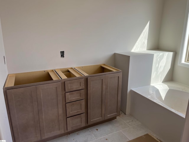 bathroom with tile patterned floors and a tub