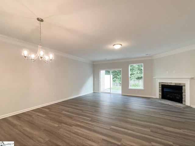 unfurnished living room with crown molding, dark wood-type flooring, a chandelier, and a fireplace