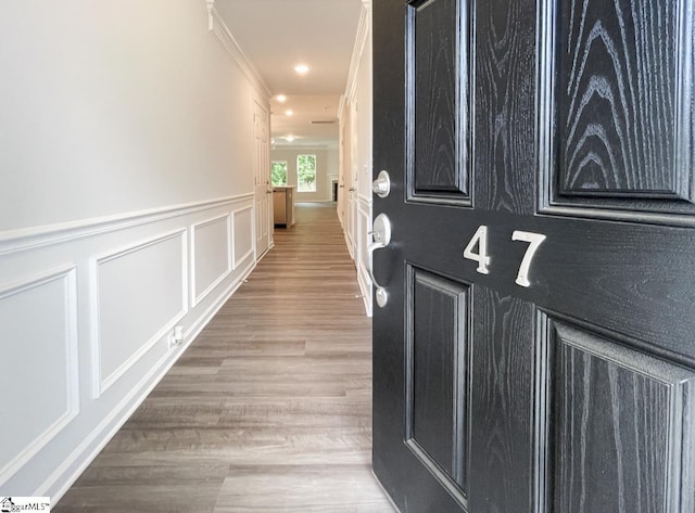 hall with ornamental molding and light wood-type flooring