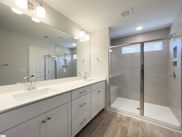 bathroom with vanity, wood-type flooring, and walk in shower