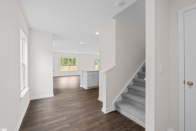 staircase with baseboards, wood finished floors, and recessed lighting