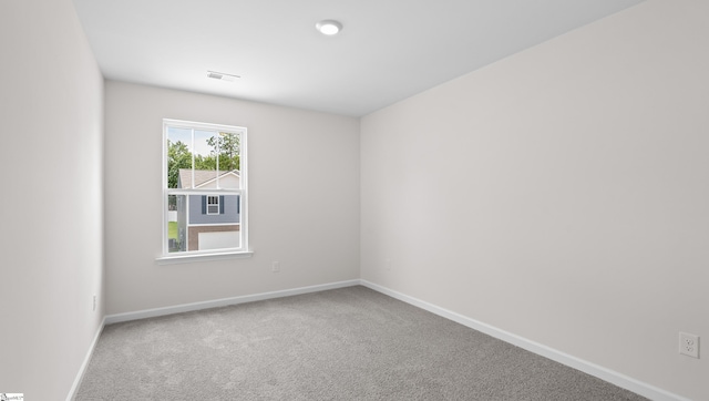 carpeted empty room with visible vents and baseboards