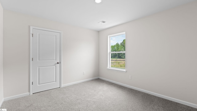 carpeted spare room with visible vents and baseboards