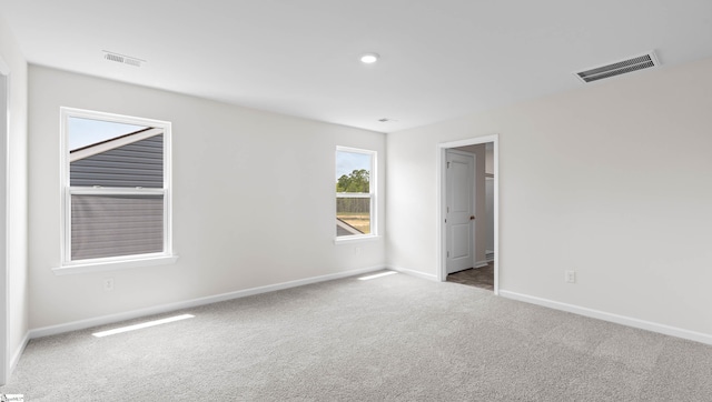 carpeted empty room with recessed lighting, visible vents, and baseboards