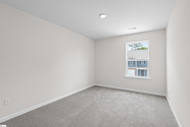 empty room featuring carpet flooring, visible vents, and baseboards