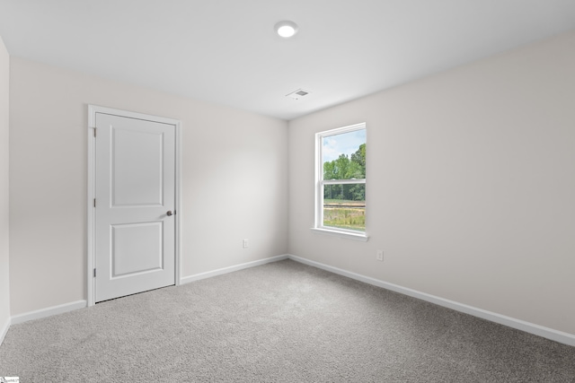 unfurnished room featuring carpet floors, visible vents, and baseboards