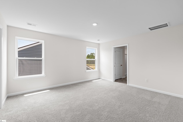 empty room with recessed lighting, carpet flooring, visible vents, and baseboards