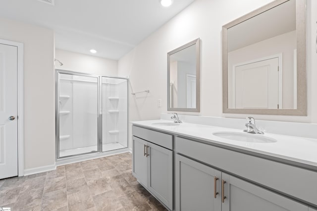 full bathroom with a stall shower, a sink, recessed lighting, and double vanity