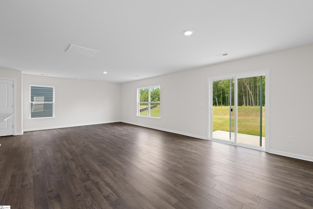 empty room with dark wood-type flooring, recessed lighting, and baseboards