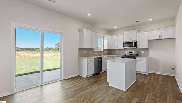 kitchen featuring white cabinets, appliances with stainless steel finishes, a kitchen island, and sink