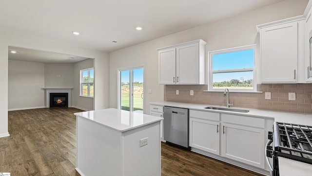 kitchen with stainless steel appliances, dark wood-type flooring, sink, white cabinets, and a kitchen island