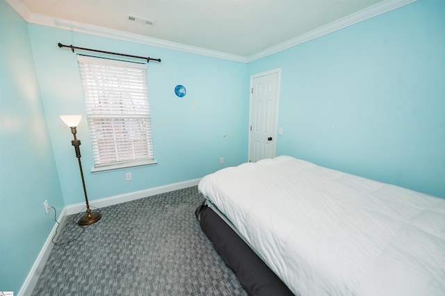 bedroom with ornamental molding and dark colored carpet