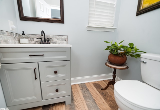 bathroom with oversized vanity, toilet, and wood-type flooring