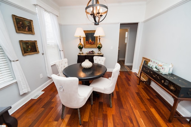 dining room featuring crown molding, dark hardwood / wood-style floors, and a chandelier