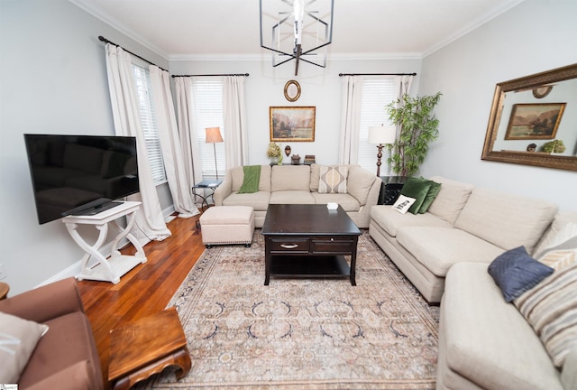 living room featuring an inviting chandelier, crown molding, hardwood / wood-style flooring, and a healthy amount of sunlight