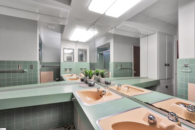 bathroom with double sink, tile walls, tile flooring, and vanity with extensive cabinet space