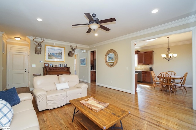 living room with ornamental molding, ceiling fan with notable chandelier, and light wood-type flooring