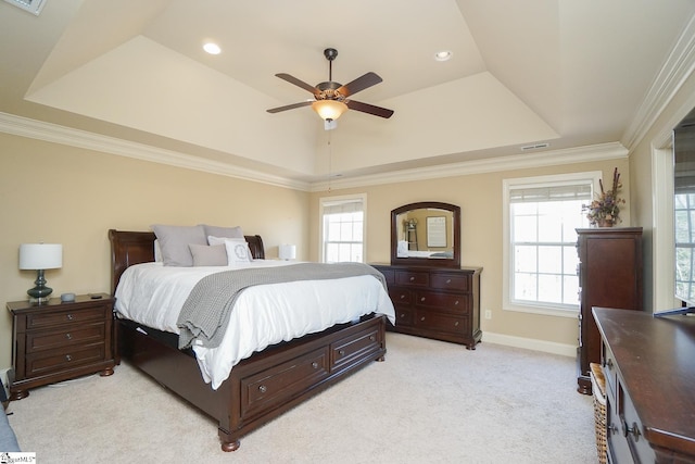 bedroom featuring ornamental molding, a tray ceiling, ceiling fan, and light colored carpet