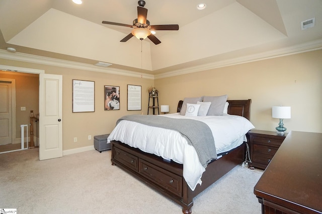 bedroom featuring a raised ceiling, ornamental molding, light colored carpet, and ceiling fan