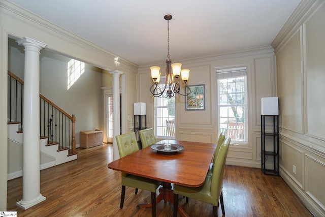 dining area with a notable chandelier, dark wood-type flooring, and ornate columns