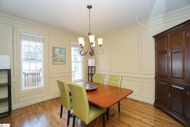 dining area with an inviting chandelier, crown molding, and light wood-type flooring