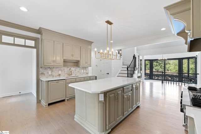 kitchen featuring an inviting chandelier, a kitchen island, sink, and light hardwood / wood-style floors