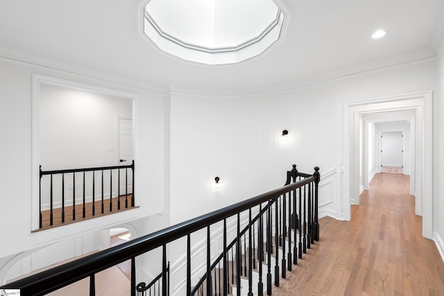 corridor featuring crown molding and light hardwood / wood-style flooring