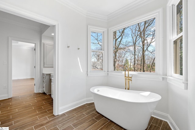 bathroom with a bathing tub, hardwood / wood-style flooring, and ornamental molding