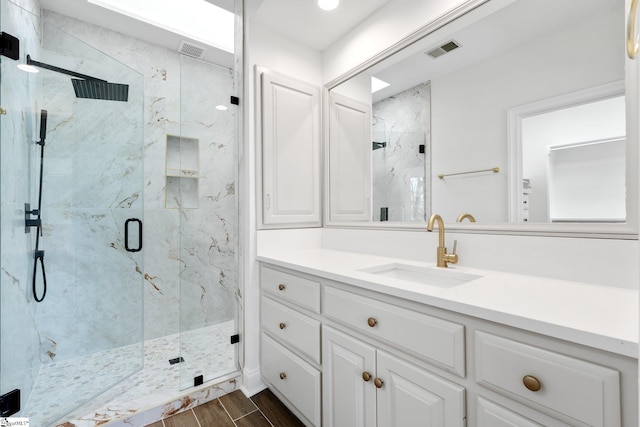 bathroom with a shower with door, vanity with extensive cabinet space, and tile flooring